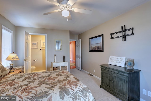 bedroom featuring ensuite bathroom, light carpet, and ceiling fan