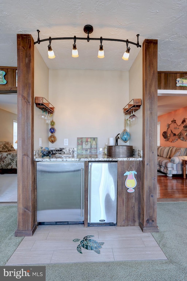 kitchen with dishwasher, stainless steel fridge, fridge, light colored carpet, and track lighting