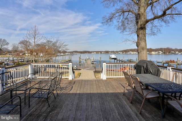 wooden terrace featuring grilling area and a water view