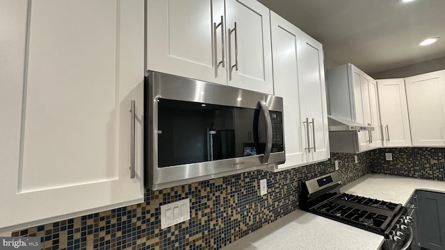 kitchen with tasteful backsplash, stainless steel appliances, and white cabinets