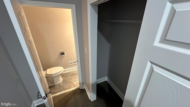 bathroom with wood-type flooring and toilet