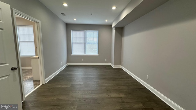 empty room featuring dark hardwood / wood-style flooring and plenty of natural light