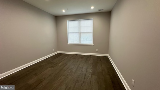 spare room with dark wood-type flooring