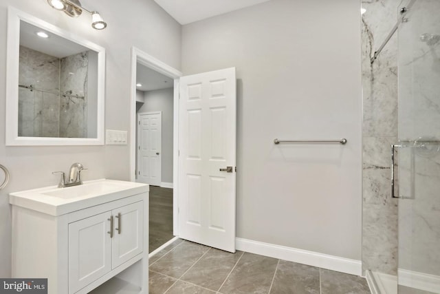 bathroom with tile patterned flooring, vanity, and a tile shower