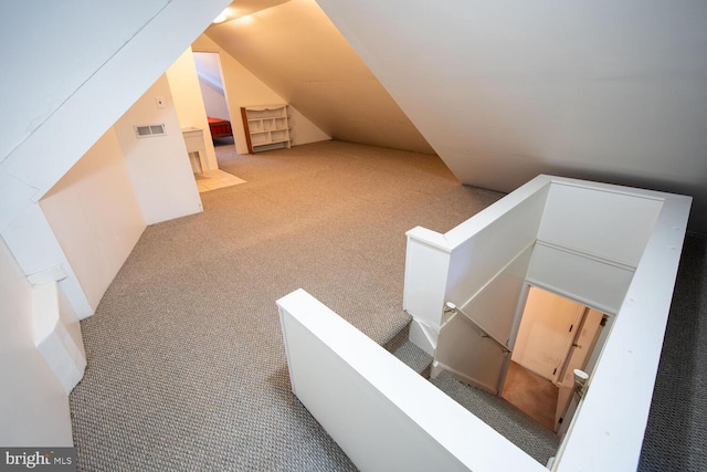 staircase with lofted ceiling and carpet flooring