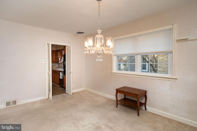 carpeted dining area with a chandelier