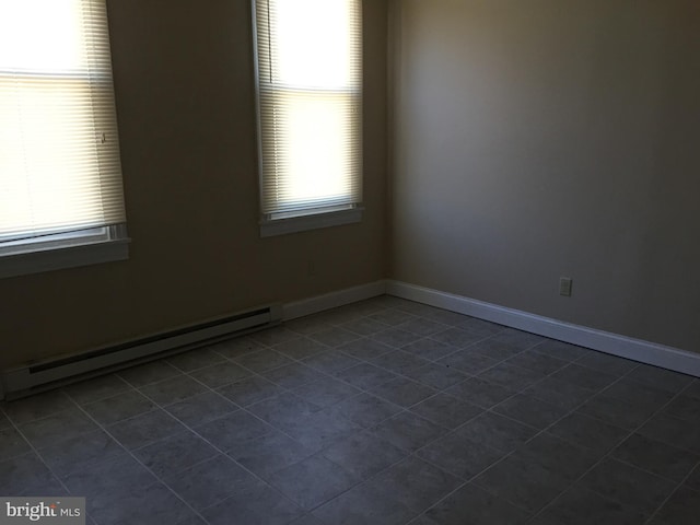 tiled spare room featuring a baseboard radiator