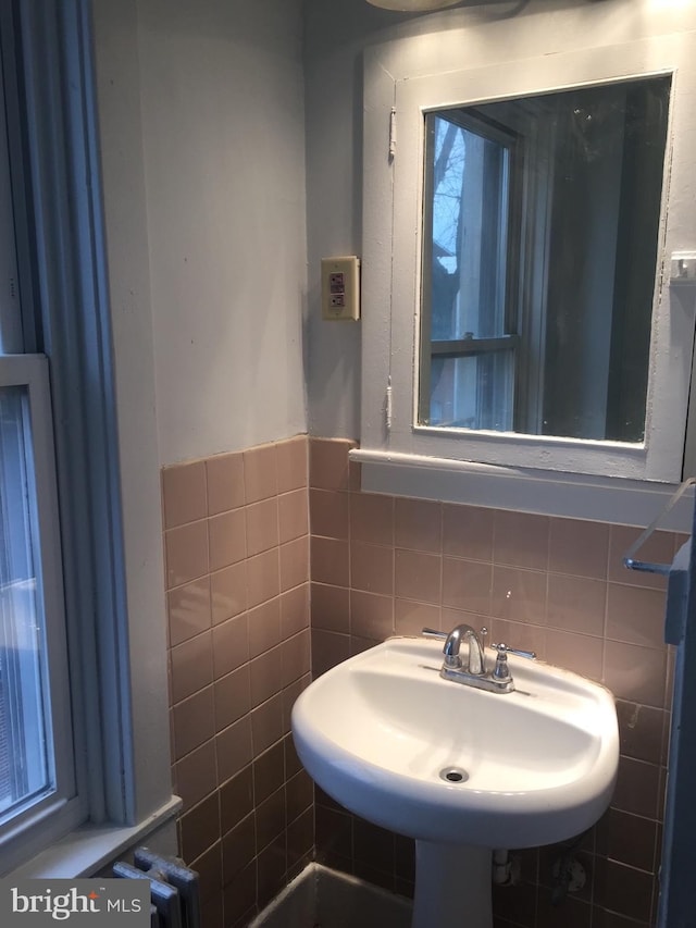 bathroom featuring sink and tile walls