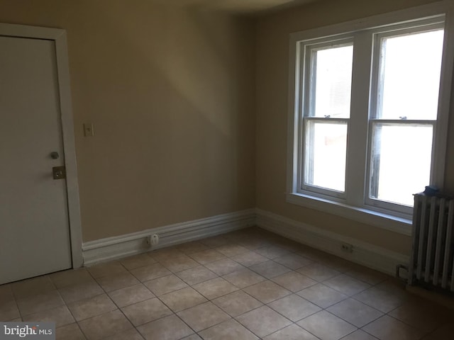 tiled empty room featuring radiator