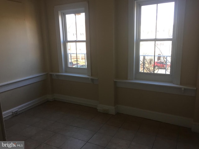 spare room featuring tile patterned floors and a wealth of natural light