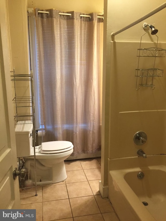 bathroom featuring tile patterned floors, toilet, and tub / shower combination