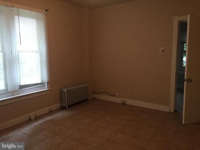 unfurnished room with radiator heating unit