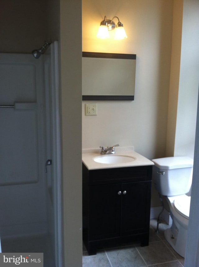 bathroom featuring vanity, tile patterned flooring, and toilet