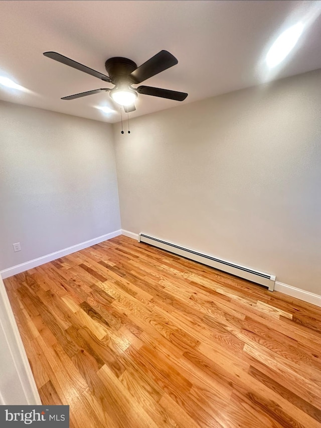 spare room with light hardwood / wood-style flooring, a baseboard radiator, and ceiling fan