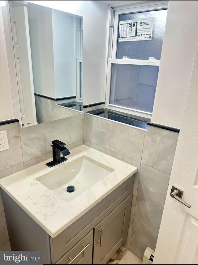 bathroom featuring vanity, tile walls, and backsplash