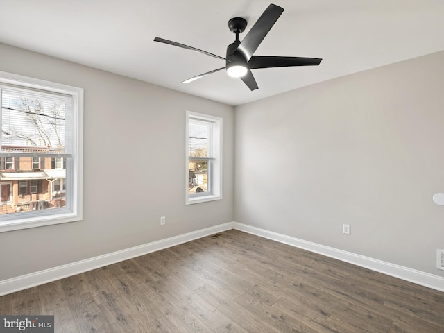 spare room featuring dark wood-type flooring and ceiling fan