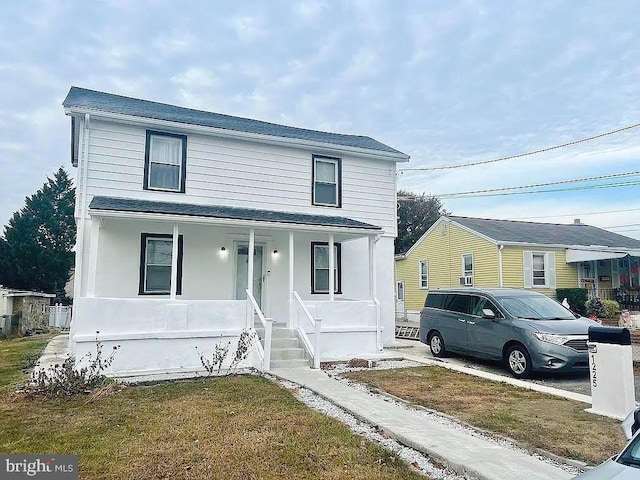 view of property featuring a front yard and covered porch