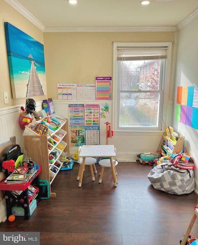 recreation room with crown molding, a wealth of natural light, and dark hardwood / wood-style flooring