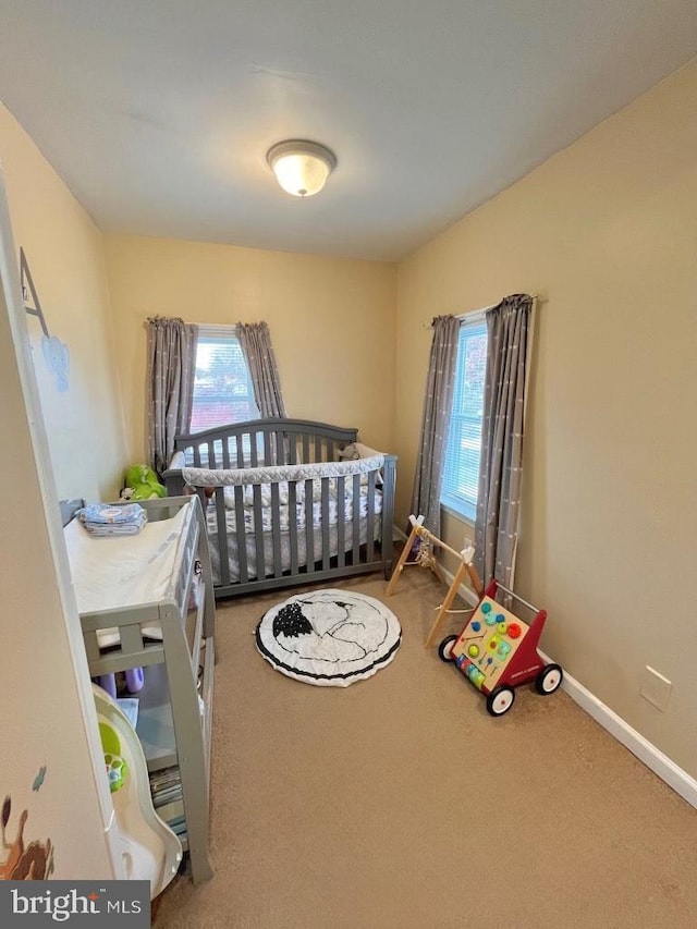 carpeted bedroom with a nursery area