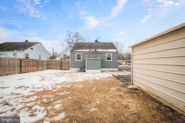 snow covered rear of property with an outdoor structure