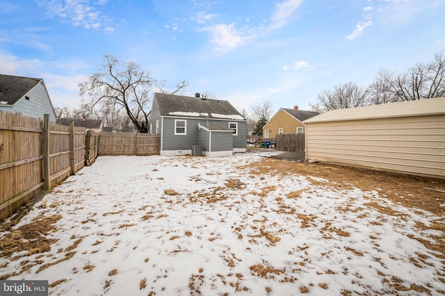 view of snow covered back of property