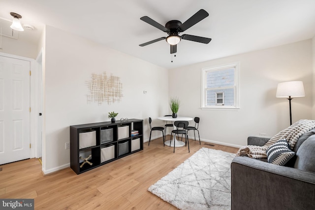 living room with light hardwood / wood-style flooring and ceiling fan