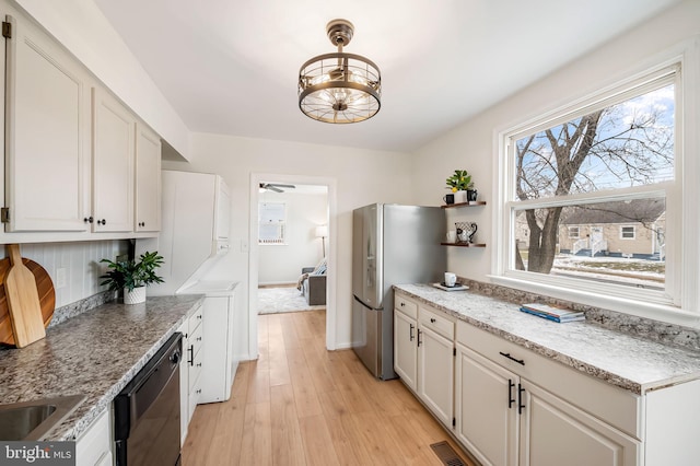 kitchen with stainless steel refrigerator, black dishwasher, white cabinets, ceiling fan, and light wood-type flooring