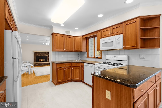 kitchen with sink, crown molding, white appliances, a fireplace, and kitchen peninsula