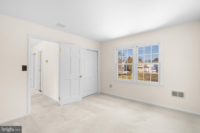 unfurnished bedroom featuring a closet and light carpet