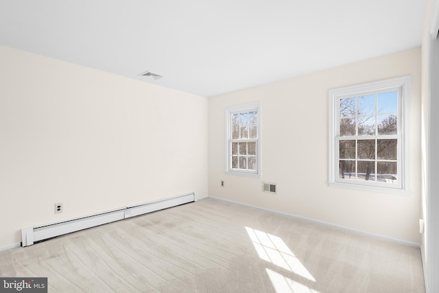 unfurnished room with light carpet, a baseboard heating unit, and a healthy amount of sunlight