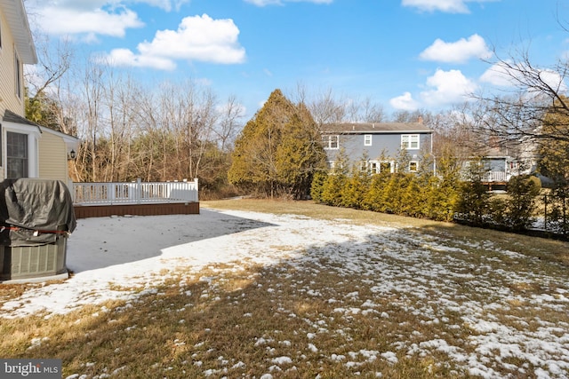 snowy yard with a deck