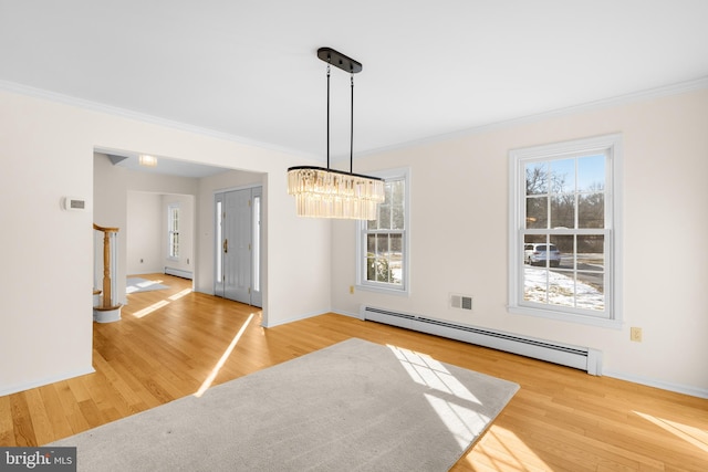 unfurnished dining area with baseboard heating, a healthy amount of sunlight, and wood-type flooring