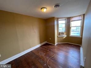 spare room featuring dark wood-type flooring