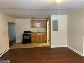 kitchen with dark hardwood / wood-style floors, electric panel, and stove