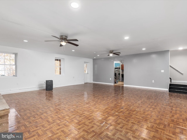 unfurnished living room featuring parquet flooring and ceiling fan