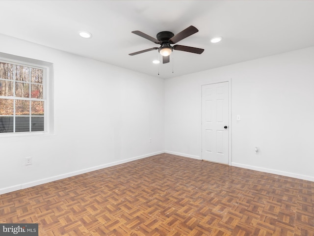 empty room featuring dark parquet floors and ceiling fan