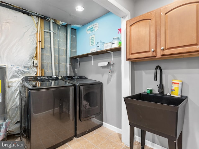 laundry area with cabinets, separate washer and dryer, sink, and light tile patterned floors