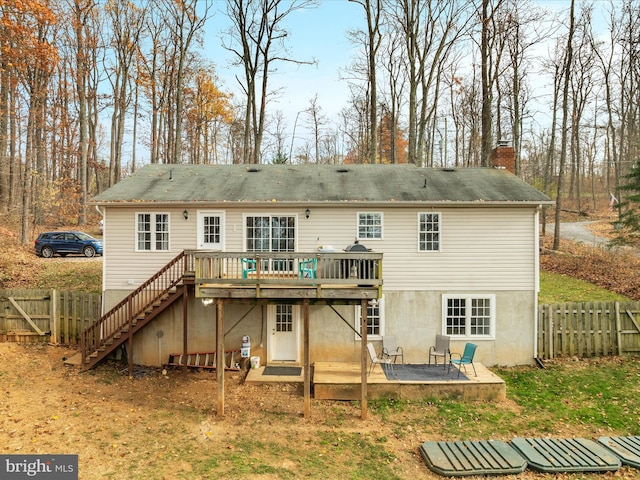 back of property featuring a wooden deck and a patio