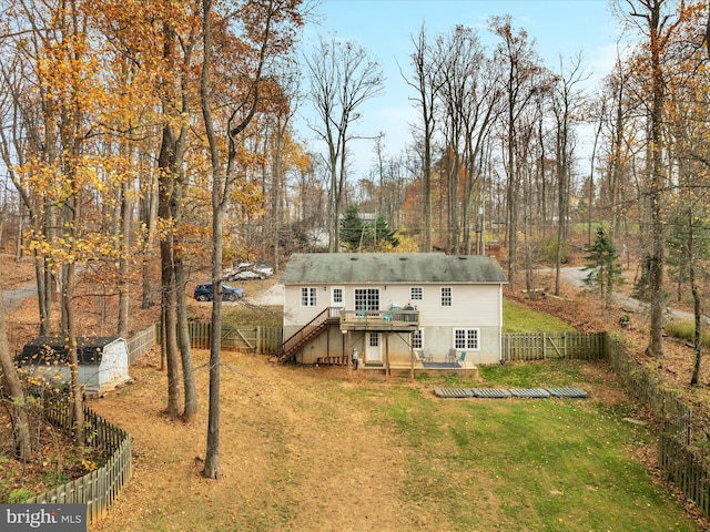 back of property featuring a deck and a lawn