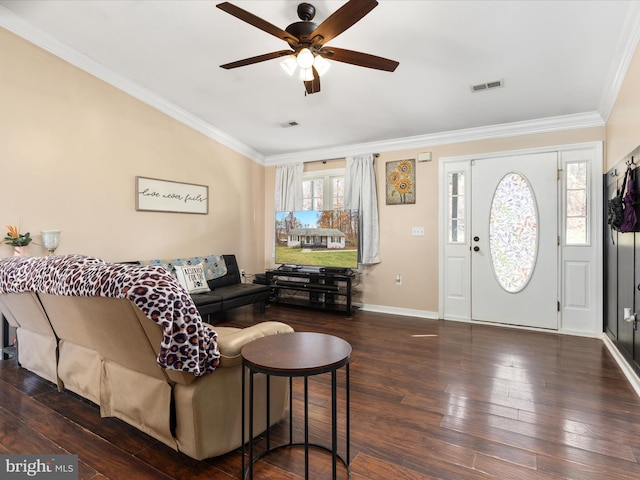 living room with dark wood-type flooring, ornamental molding, and a healthy amount of sunlight