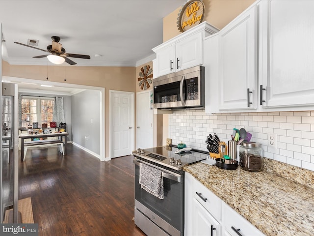 kitchen featuring crown molding, appliances with stainless steel finishes, white cabinets, dark hardwood / wood-style flooring, and decorative backsplash