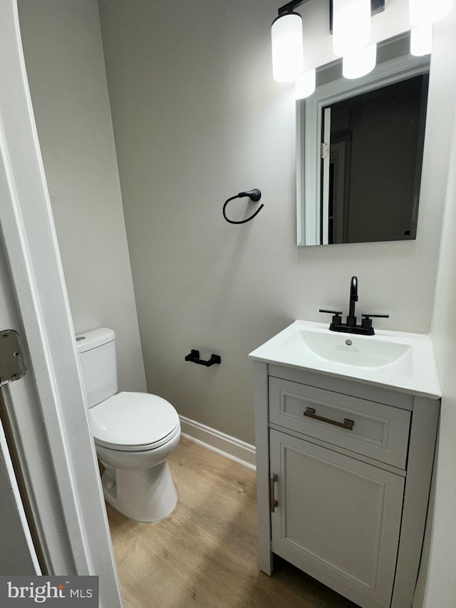 bathroom featuring vanity, hardwood / wood-style floors, and toilet