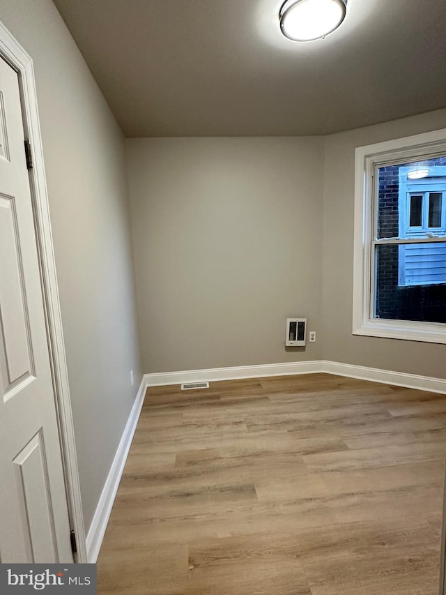 spare room with heating unit and light hardwood / wood-style flooring