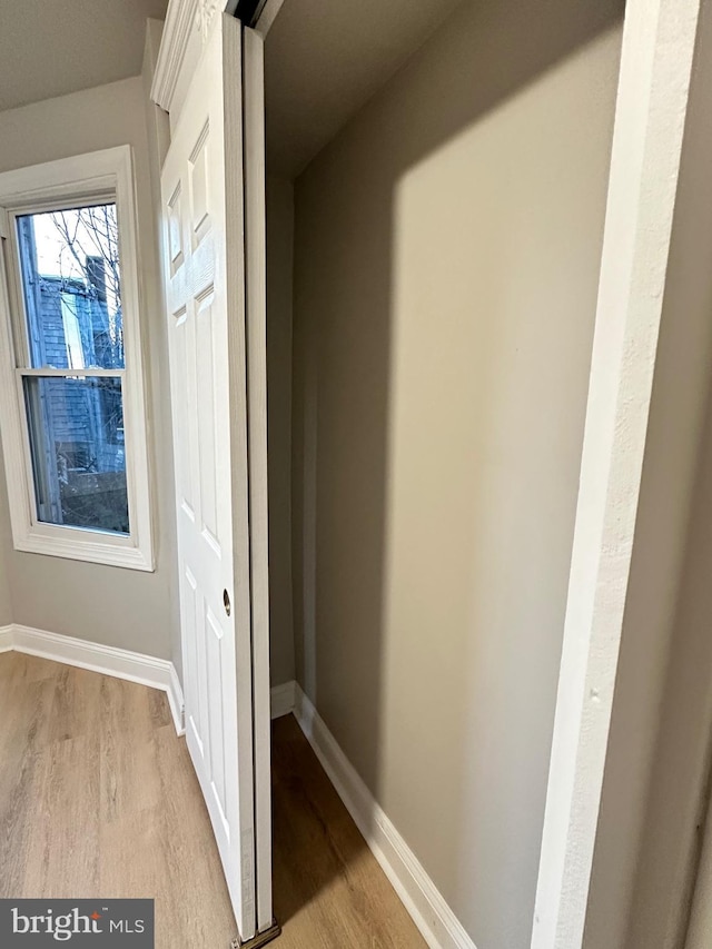 hallway with light hardwood / wood-style floors