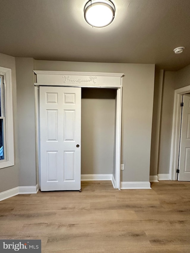 unfurnished bedroom featuring light hardwood / wood-style floors and a closet