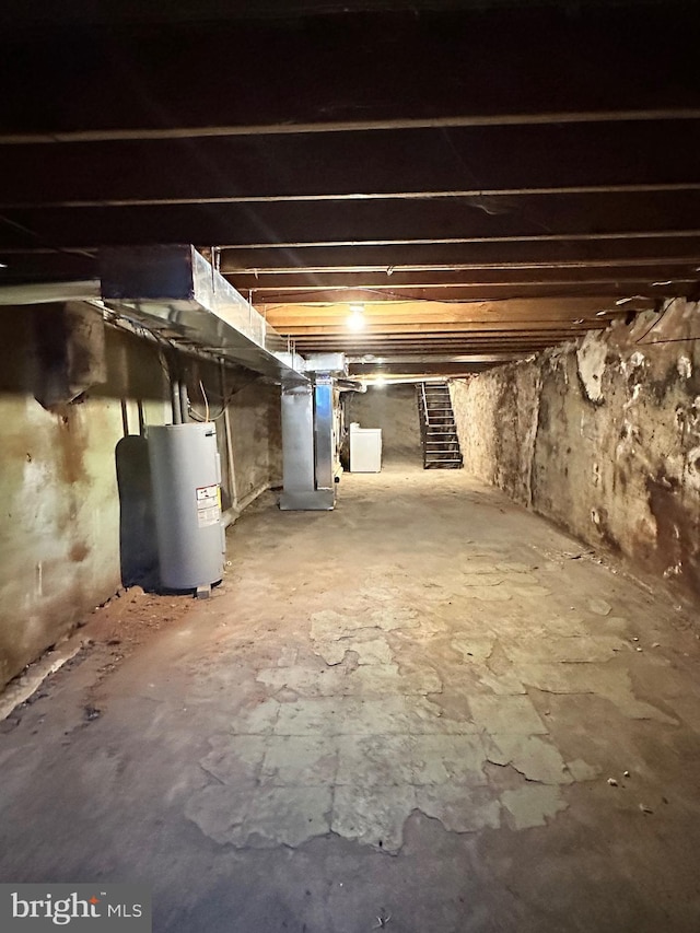 basement featuring heating unit and electric water heater