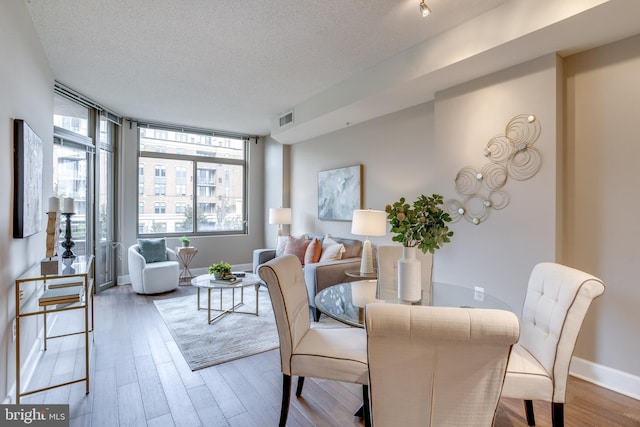 dining space featuring hardwood / wood-style flooring and a textured ceiling