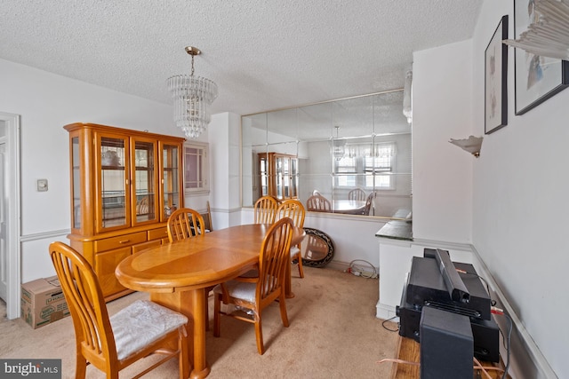 dining room with light carpet, a textured ceiling, and a chandelier