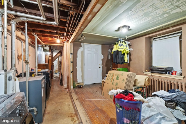 basement featuring radiator heating unit and wood-type flooring