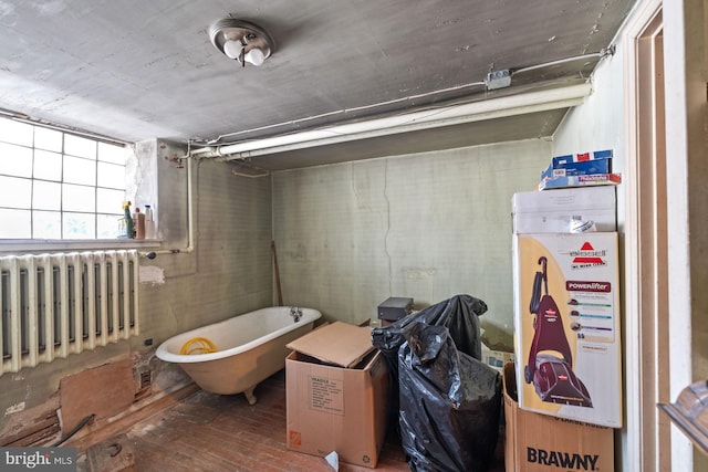 interior space featuring radiator heating unit and a tub to relax in